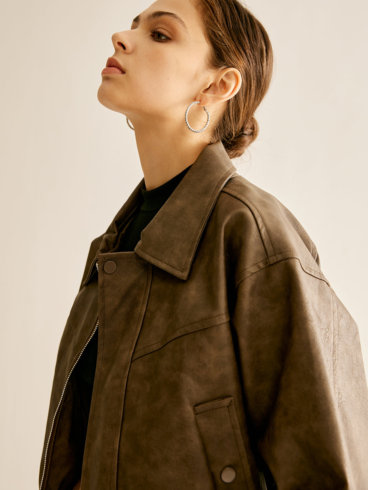 Woman wearing a brown faux leather biker jacket