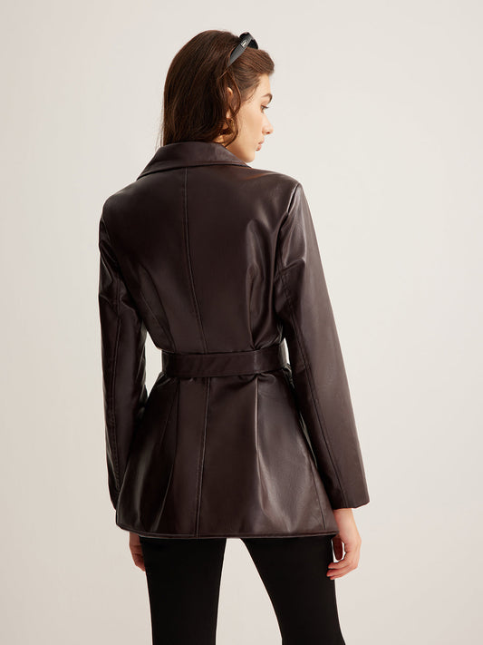 Woman wearing a belted burgundy faux leather jacket