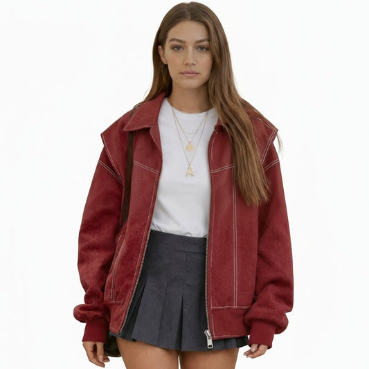 Woman wearing an oversized red faux leather bomber jacket with white contrast stitching