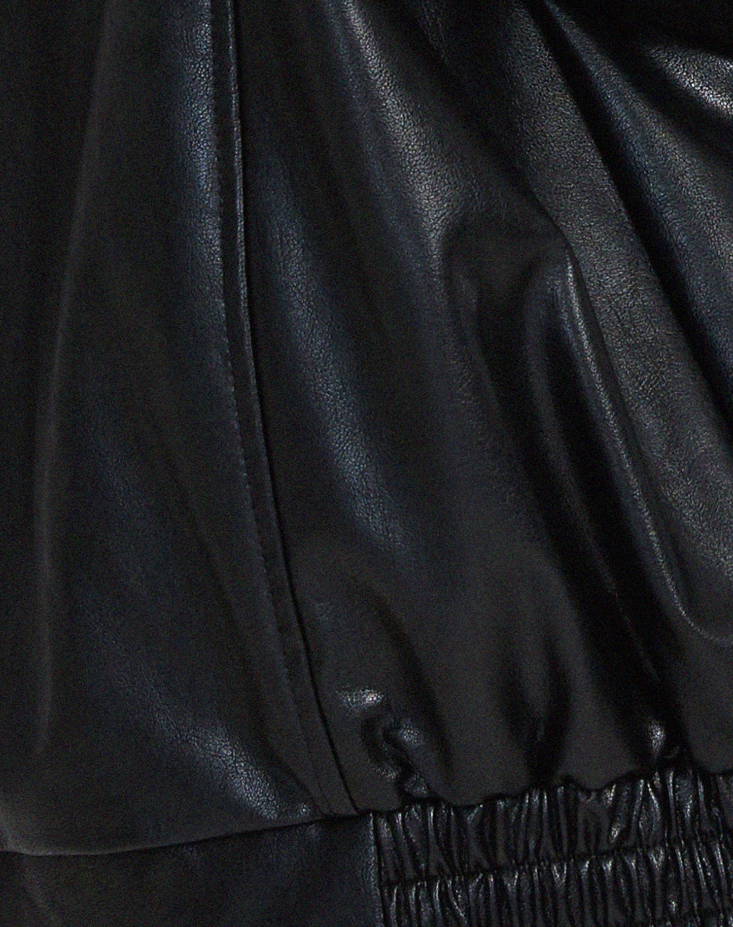 Woman wearing an oversized faux leather bomber jacket