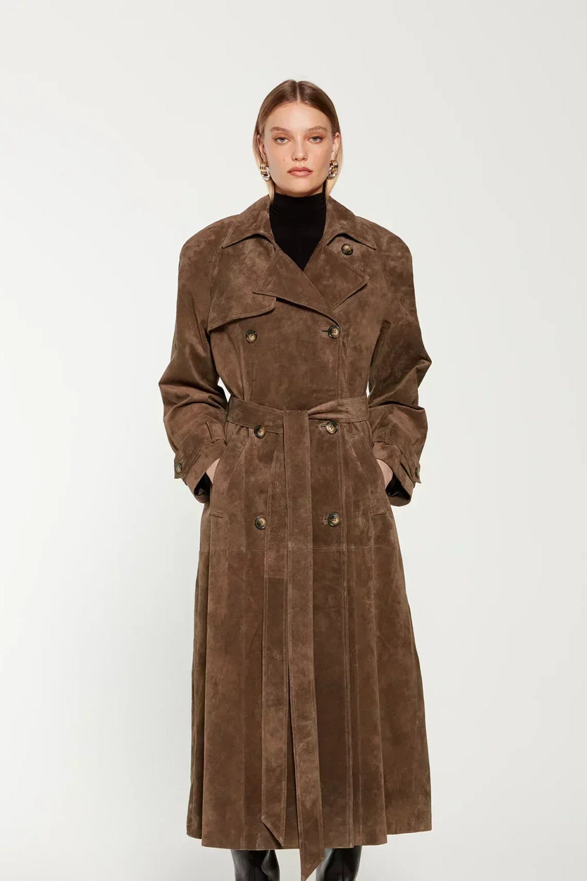 Woman wearing a long suede double-breasted belted trench coat
