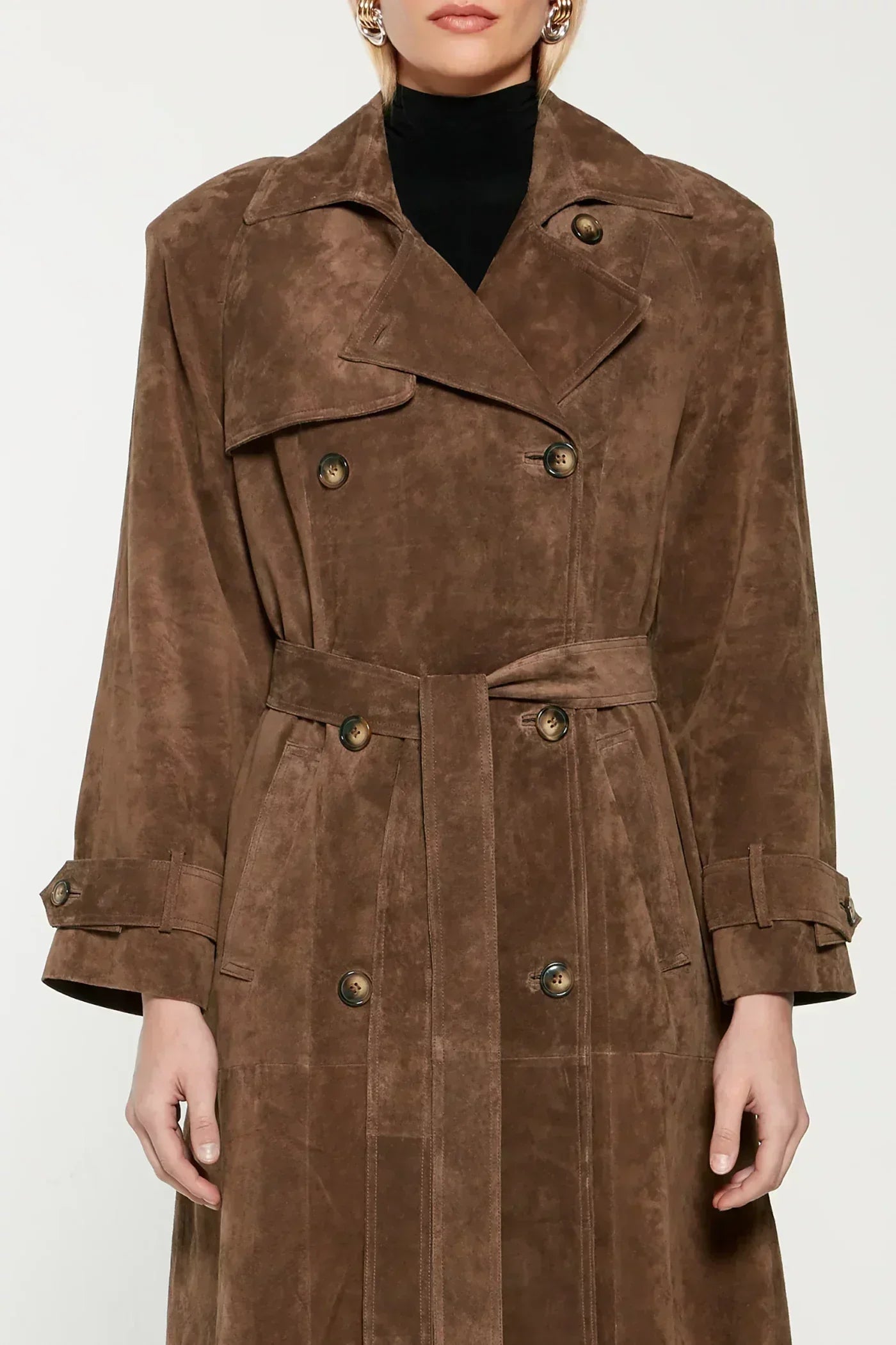 Woman wearing a long suede double-breasted belted trench coat