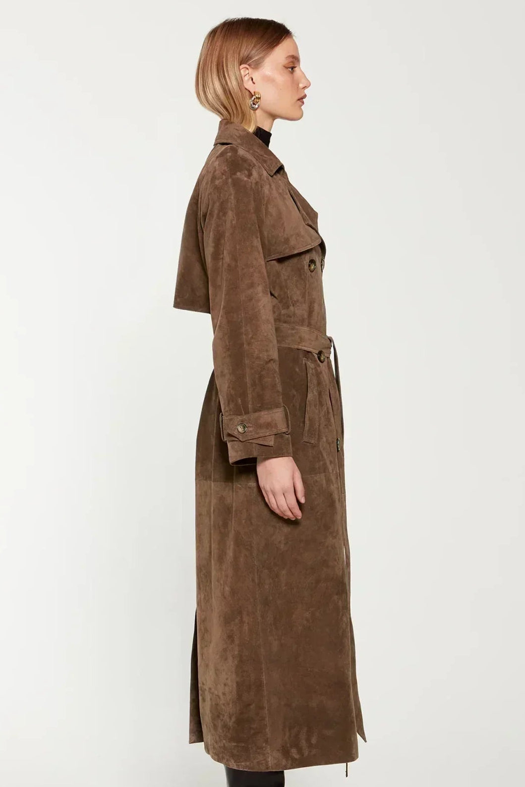 Woman wearing a long suede double-breasted belted trench coat
