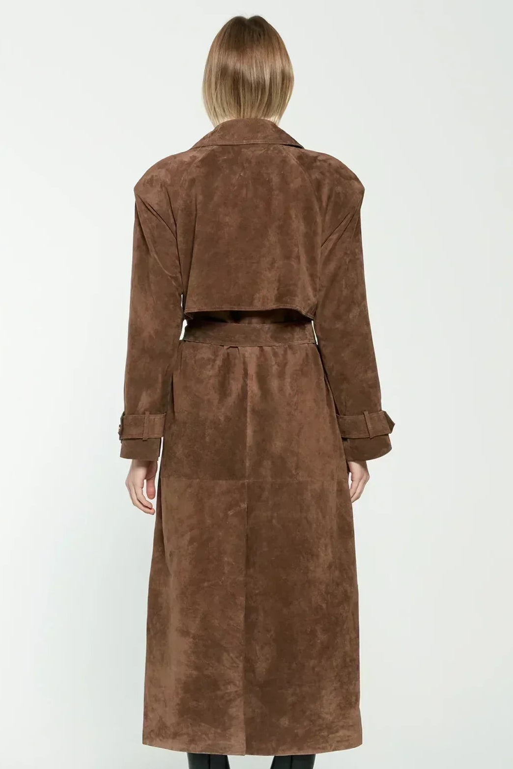 Woman wearing a long suede double-breasted belted trench coat