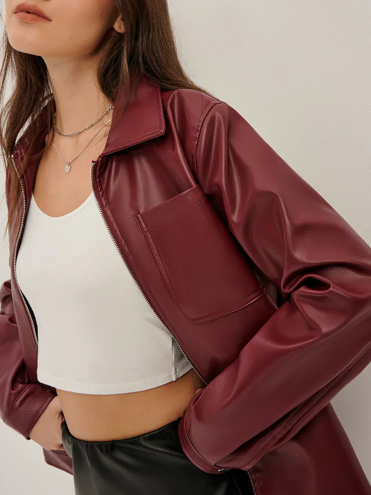Woman wearing a burgundy faux leather jacket