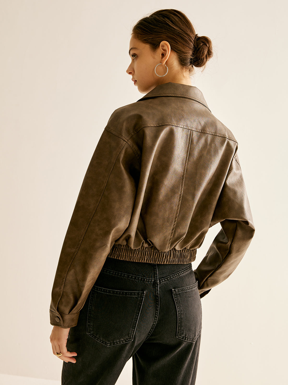 Woman wearing a brown faux leather biker jacket