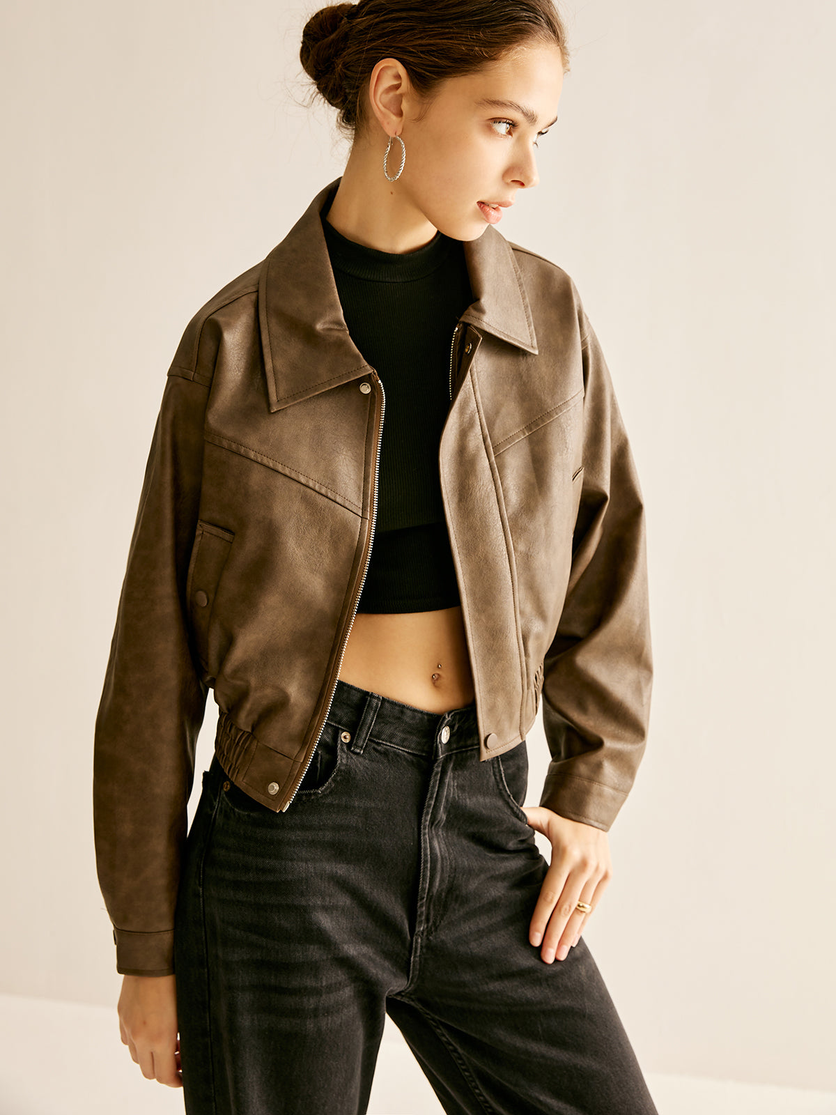 Woman wearing a brown faux leather biker jacket