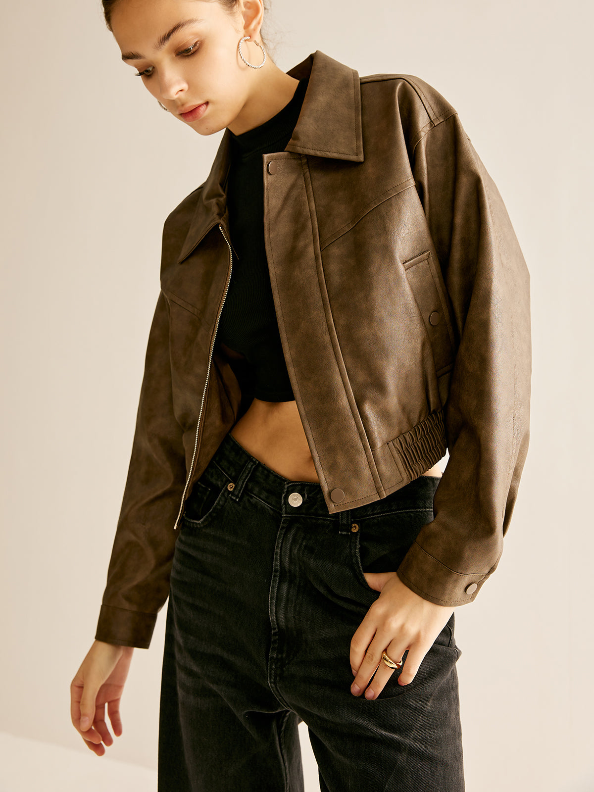 Woman wearing a brown faux leather biker jacket
