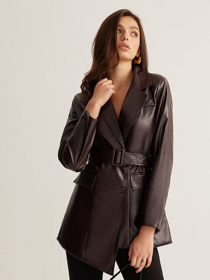 Woman wearing a belted burgundy faux leather jacket