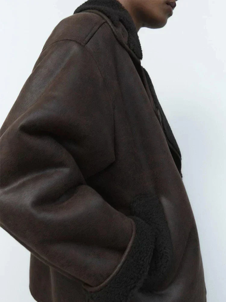 Woman wearing a draped brown faux leather jacket