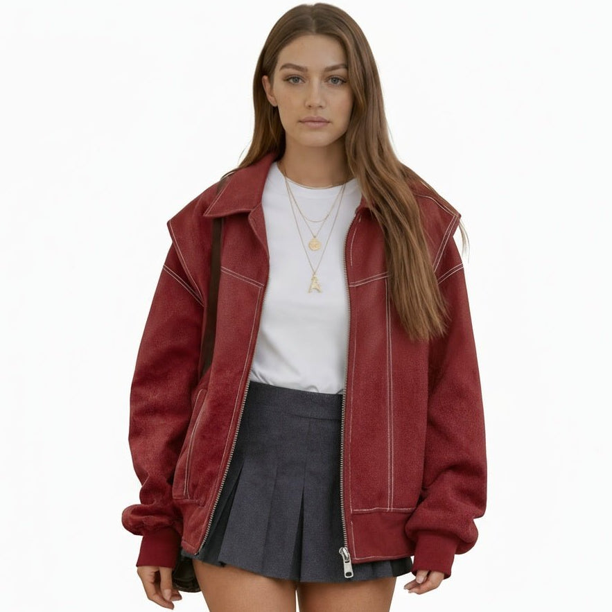 Woman wearing an oversized red faux leather bomber jacket with white contrast stitching