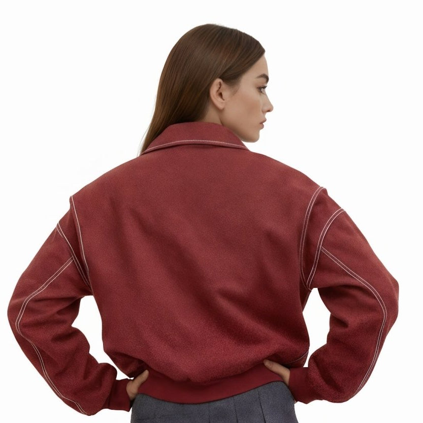 Woman wearing an oversized red faux leather bomber jacket with white contrast stitching