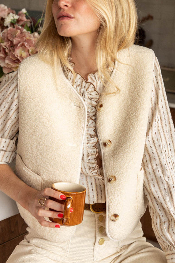 Woman wearing a cozy sherpa-textured button-up vest