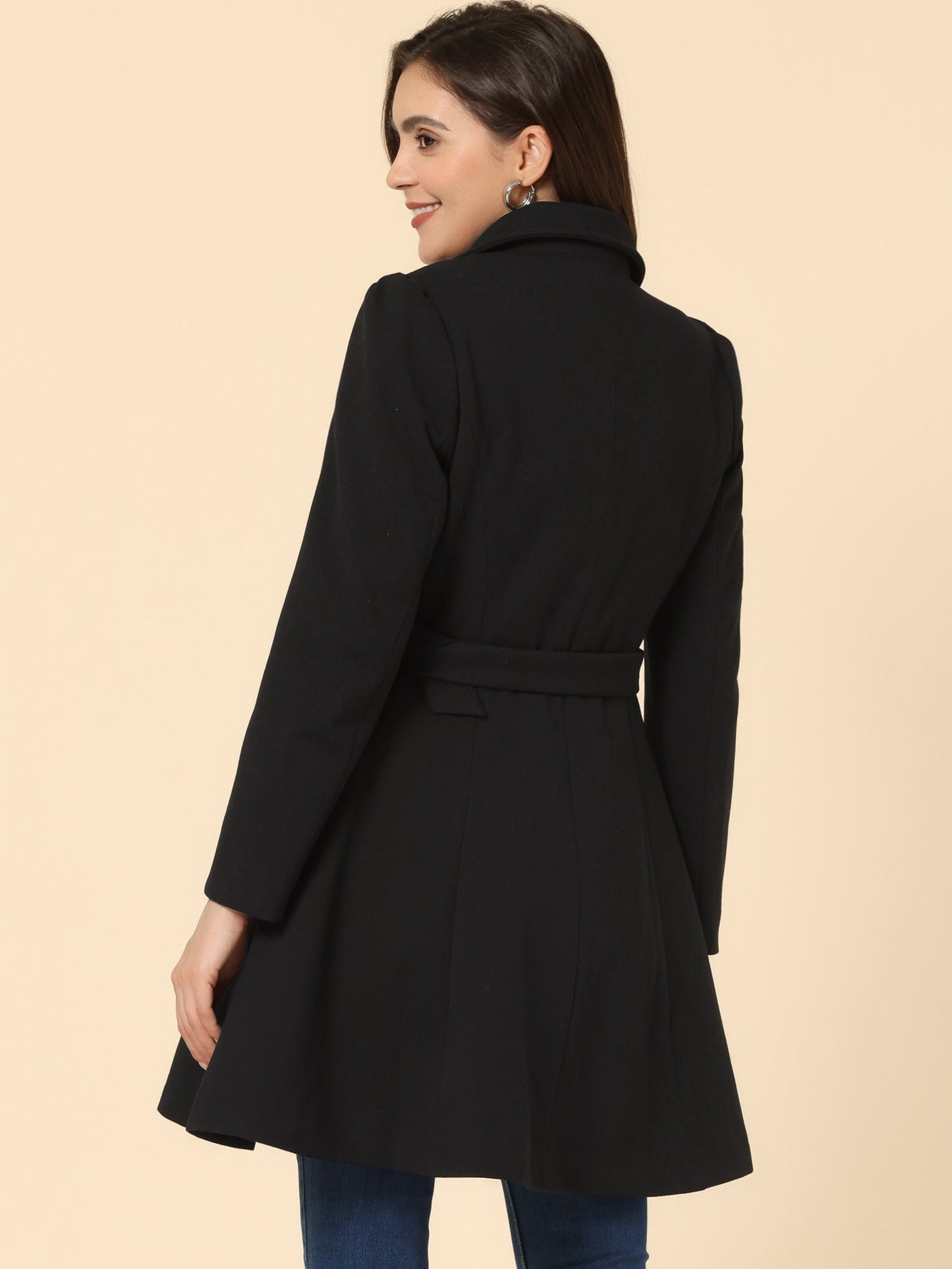 Woman wearing a double-breasted flared mid-length trench coat with notched collar