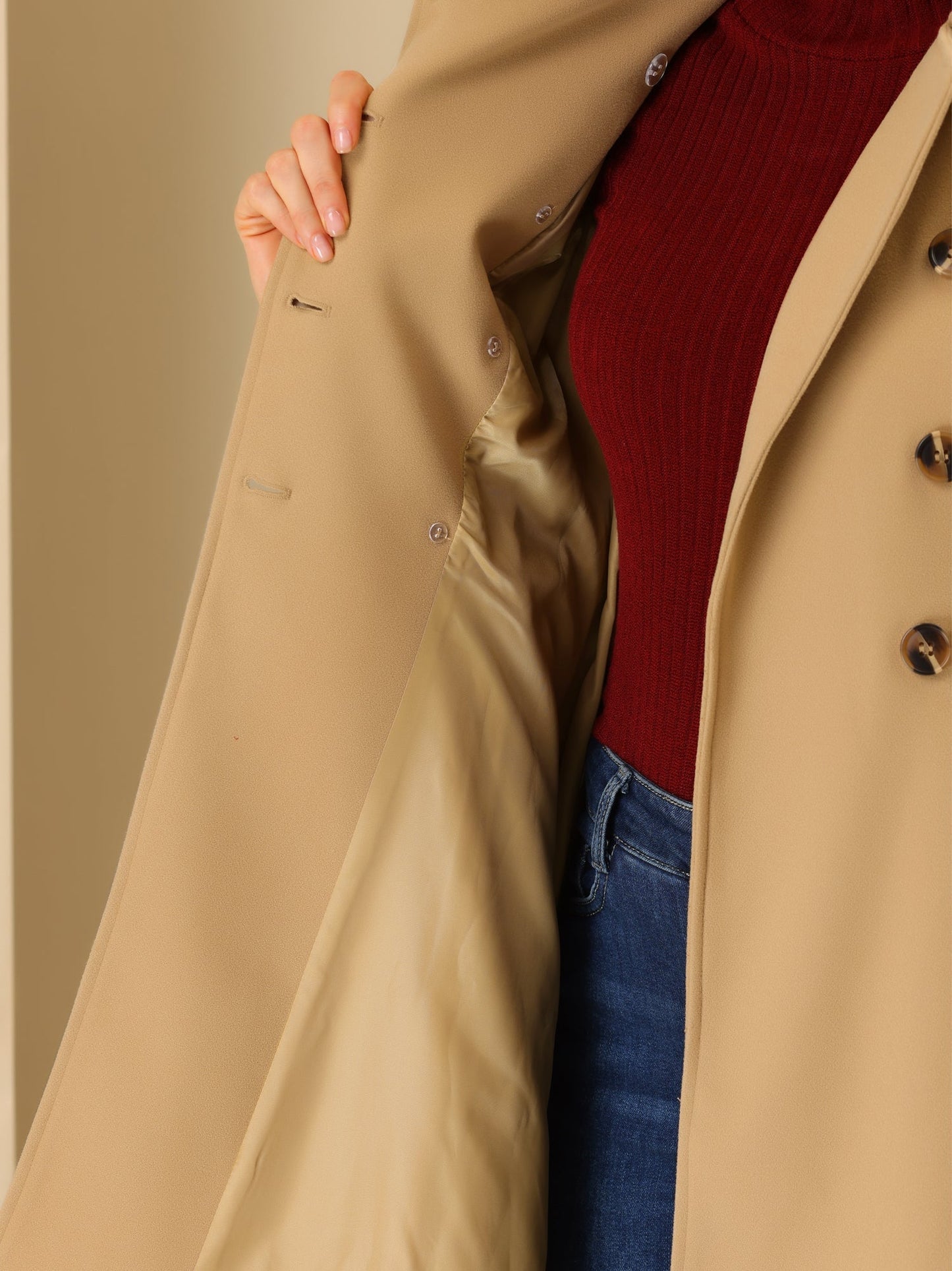 Woman wearing a double-breasted flared mid-length trench coat with notched collar