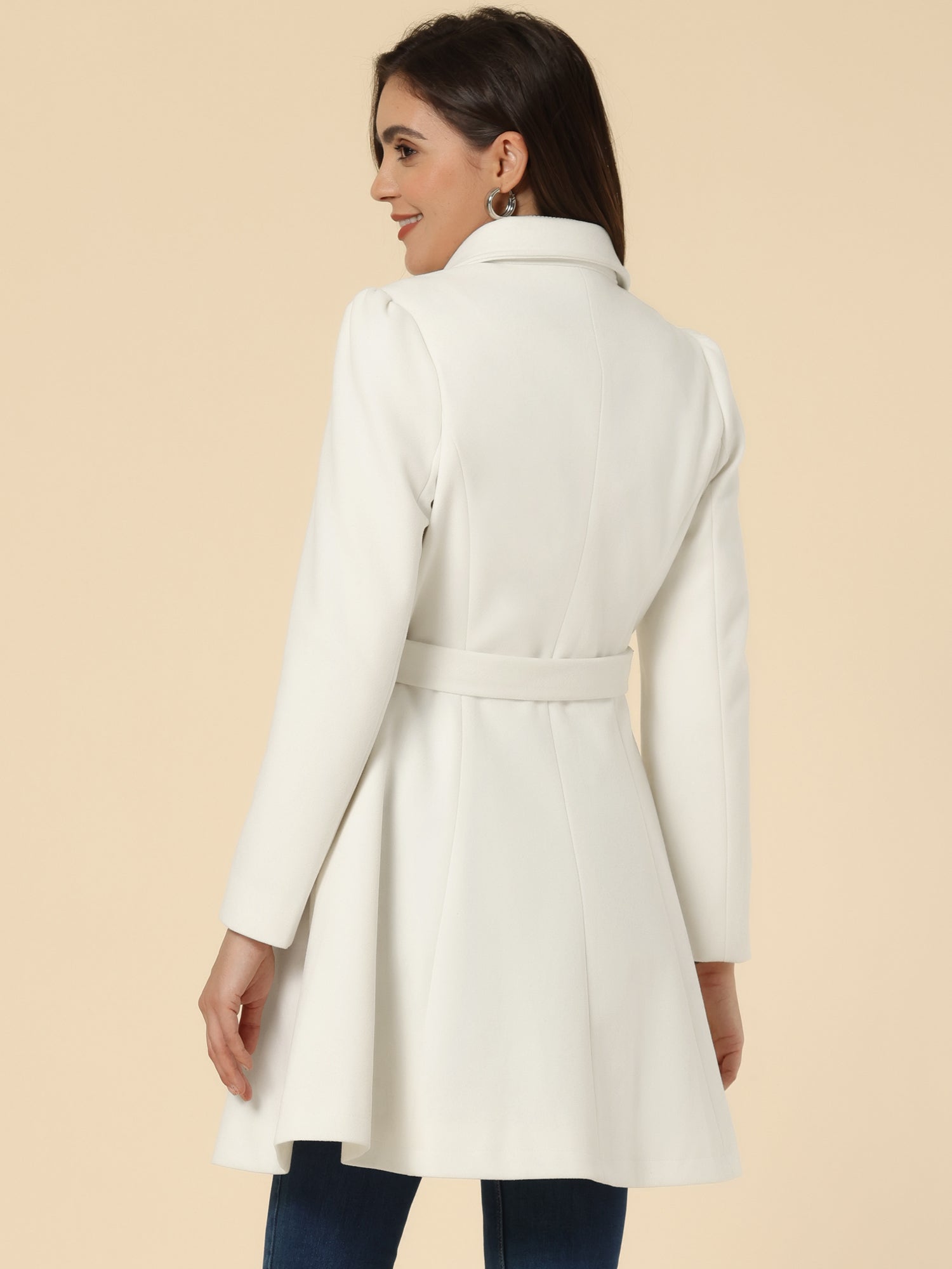 Woman wearing a double-breasted flared mid-length trench coat with notched collar