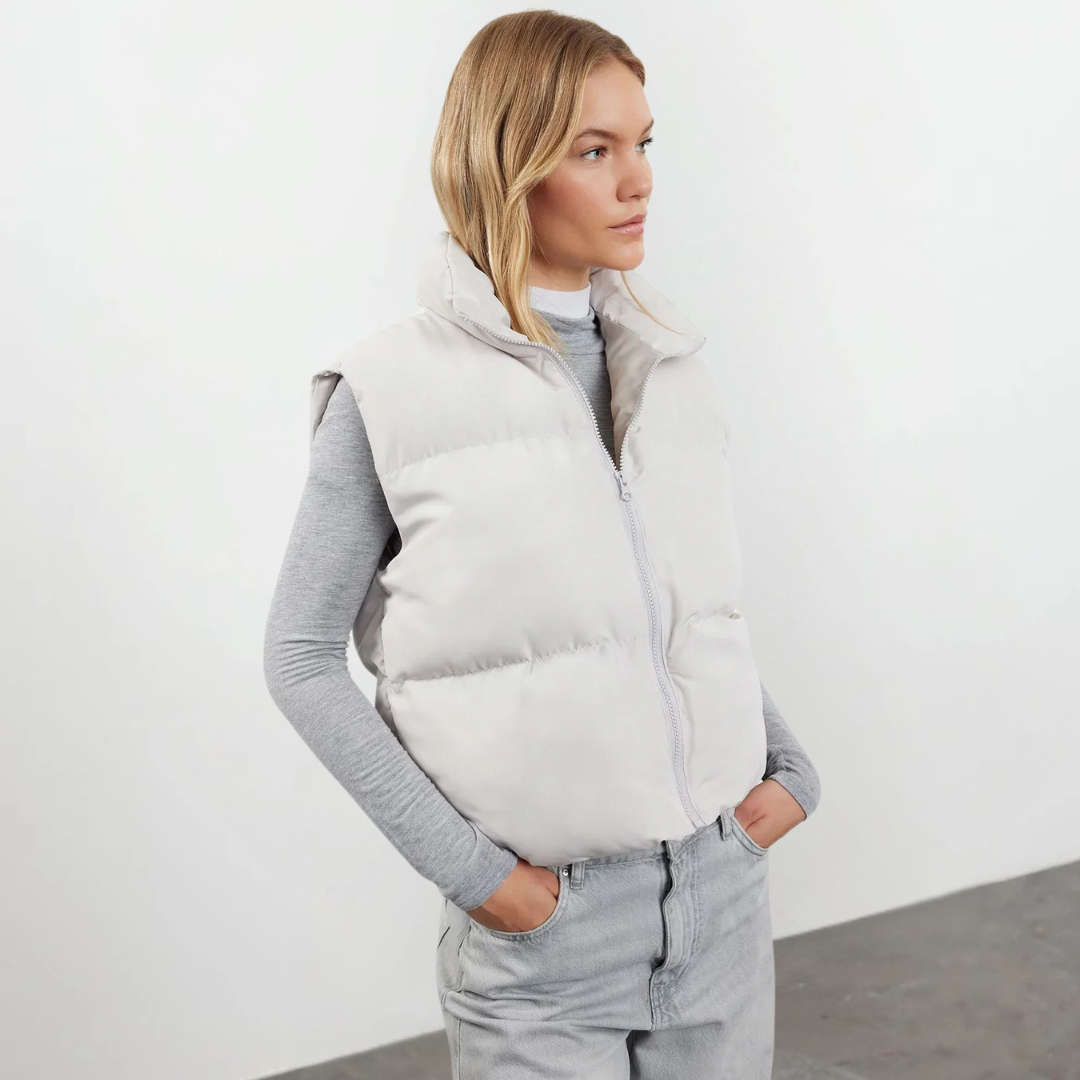 Woman wearing a lightweight quilted high collar vest