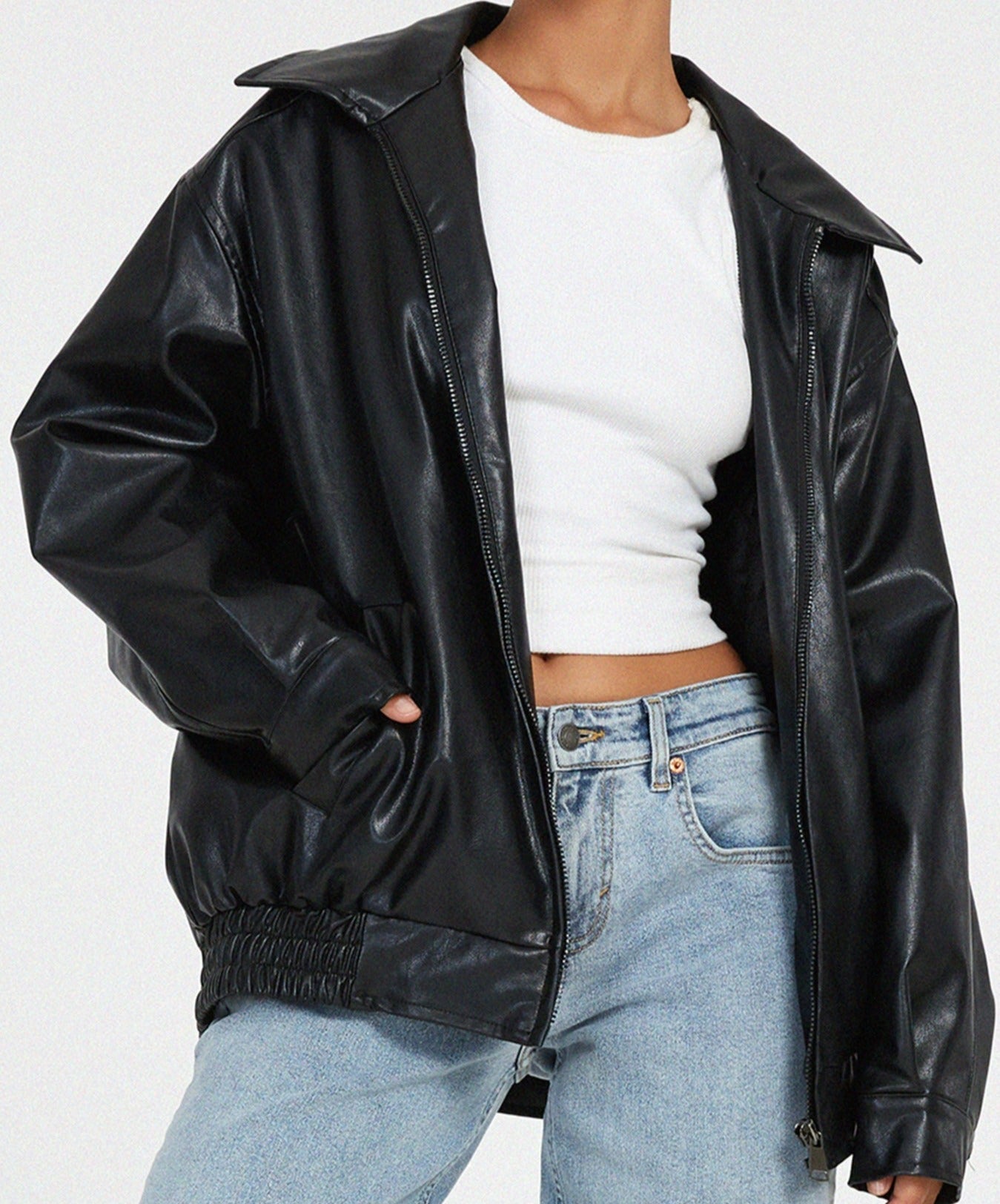 Woman wearing an oversized faux leather bomber jacket