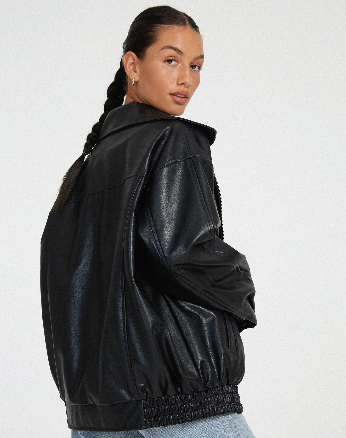 Woman wearing an oversized faux leather bomber jacket
