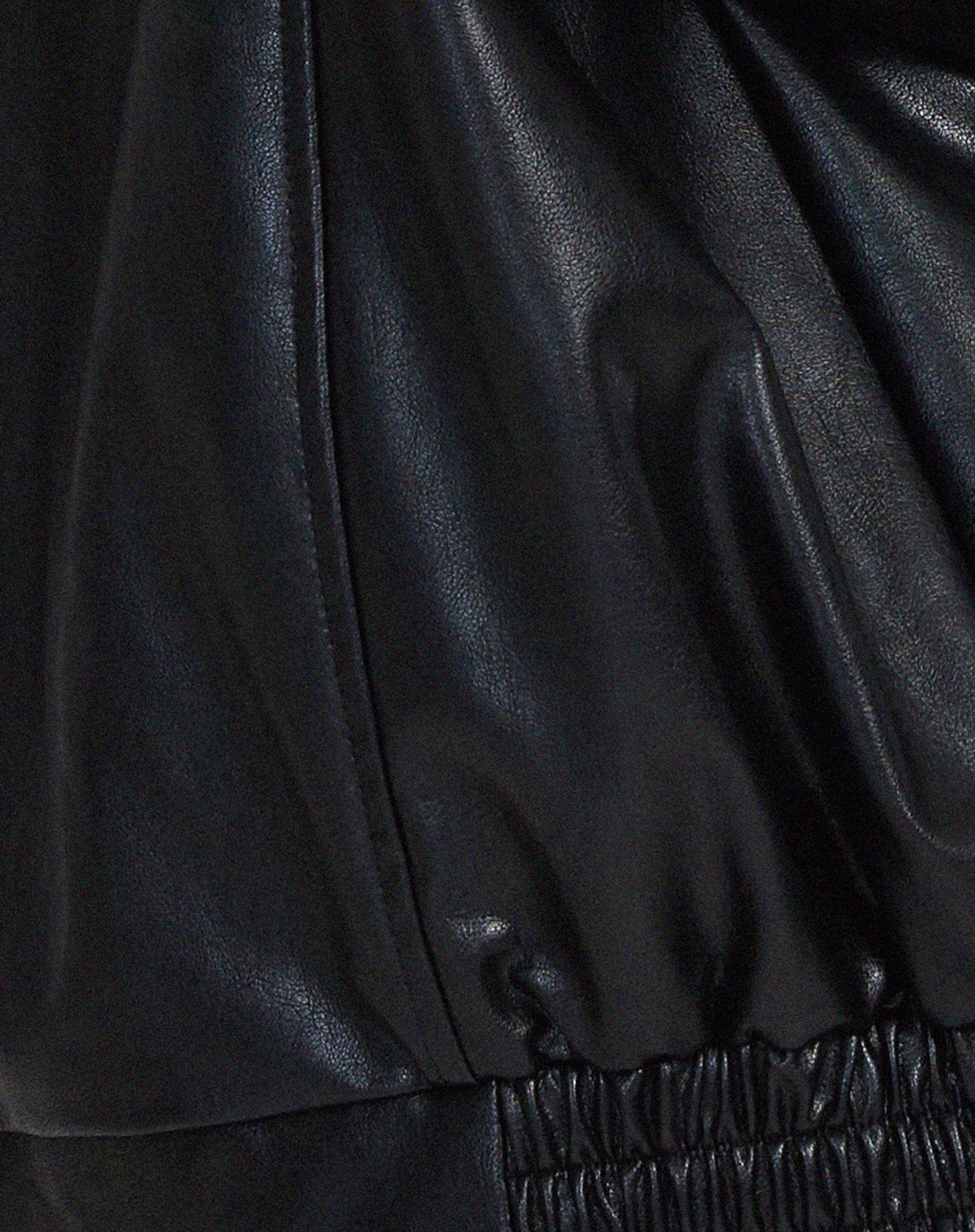 Woman wearing an oversized faux leather bomber jacket