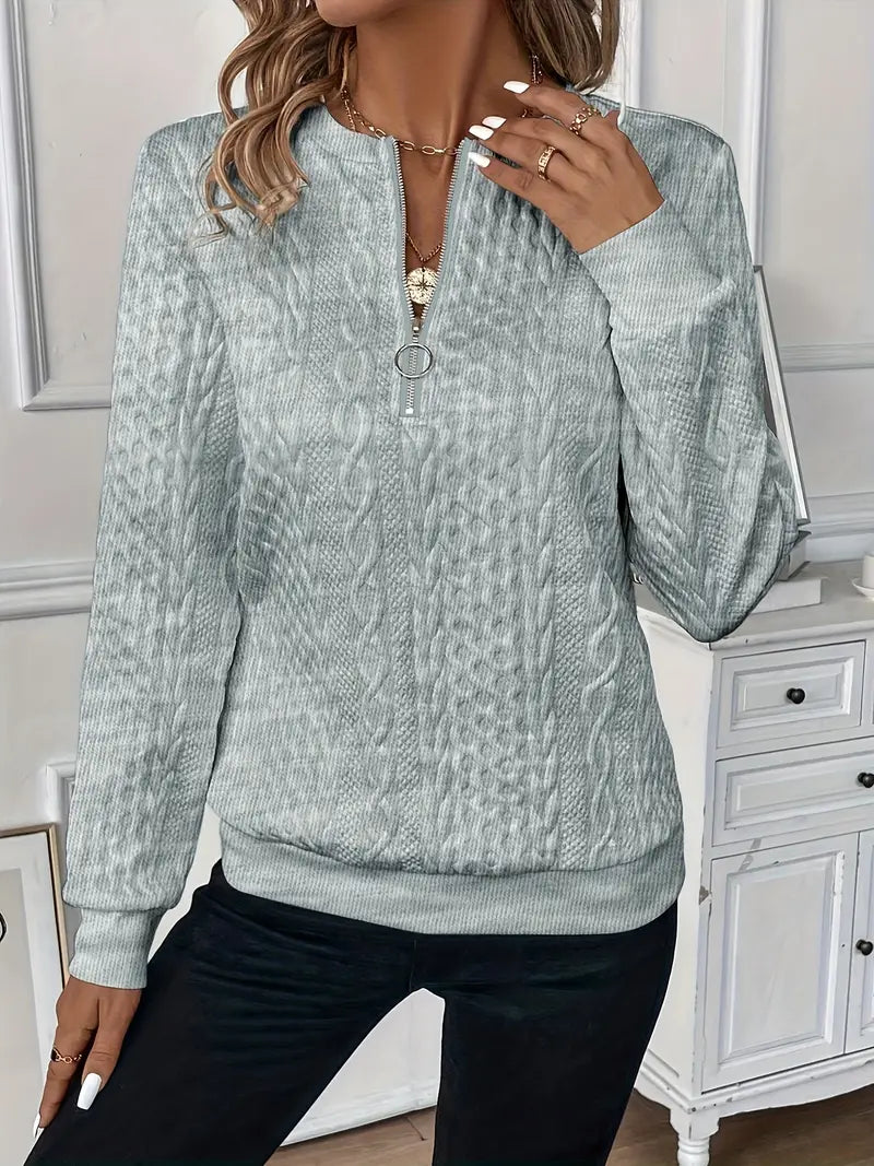 Woman wearing a cable knit quarter zip sweater
