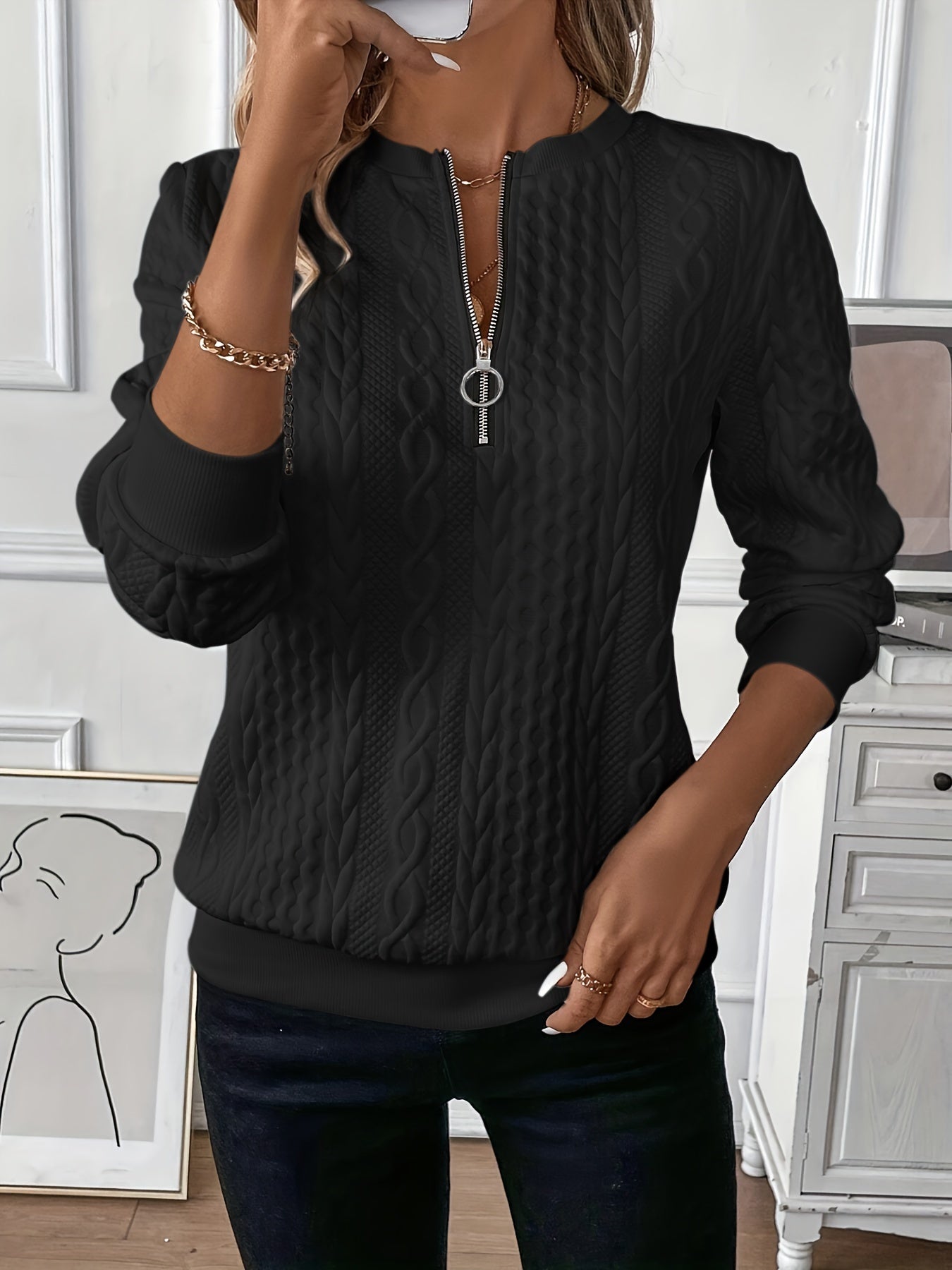 Woman wearing a cable knit quarter zip sweater
