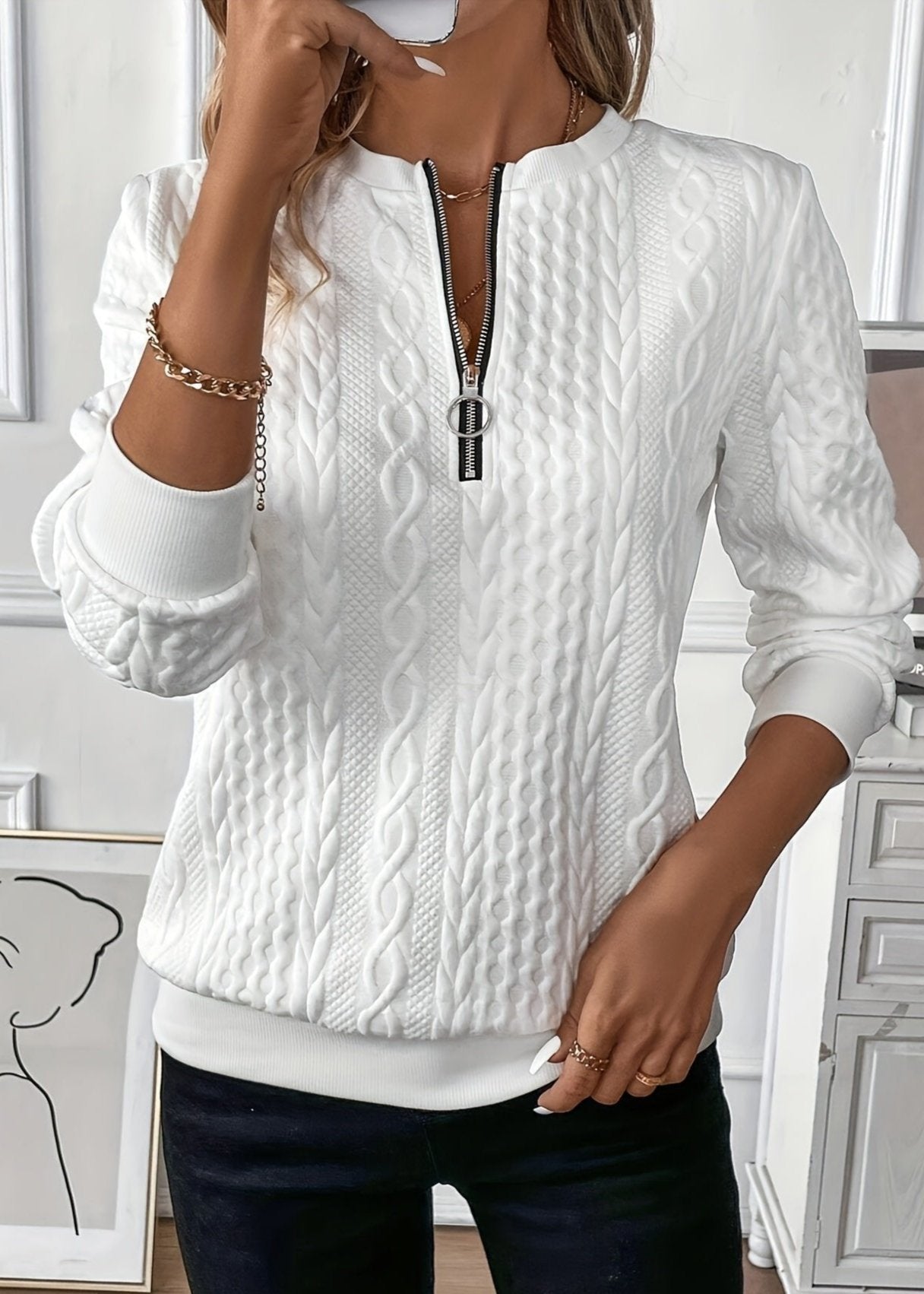 Woman wearing a cable knit quarter zip sweater