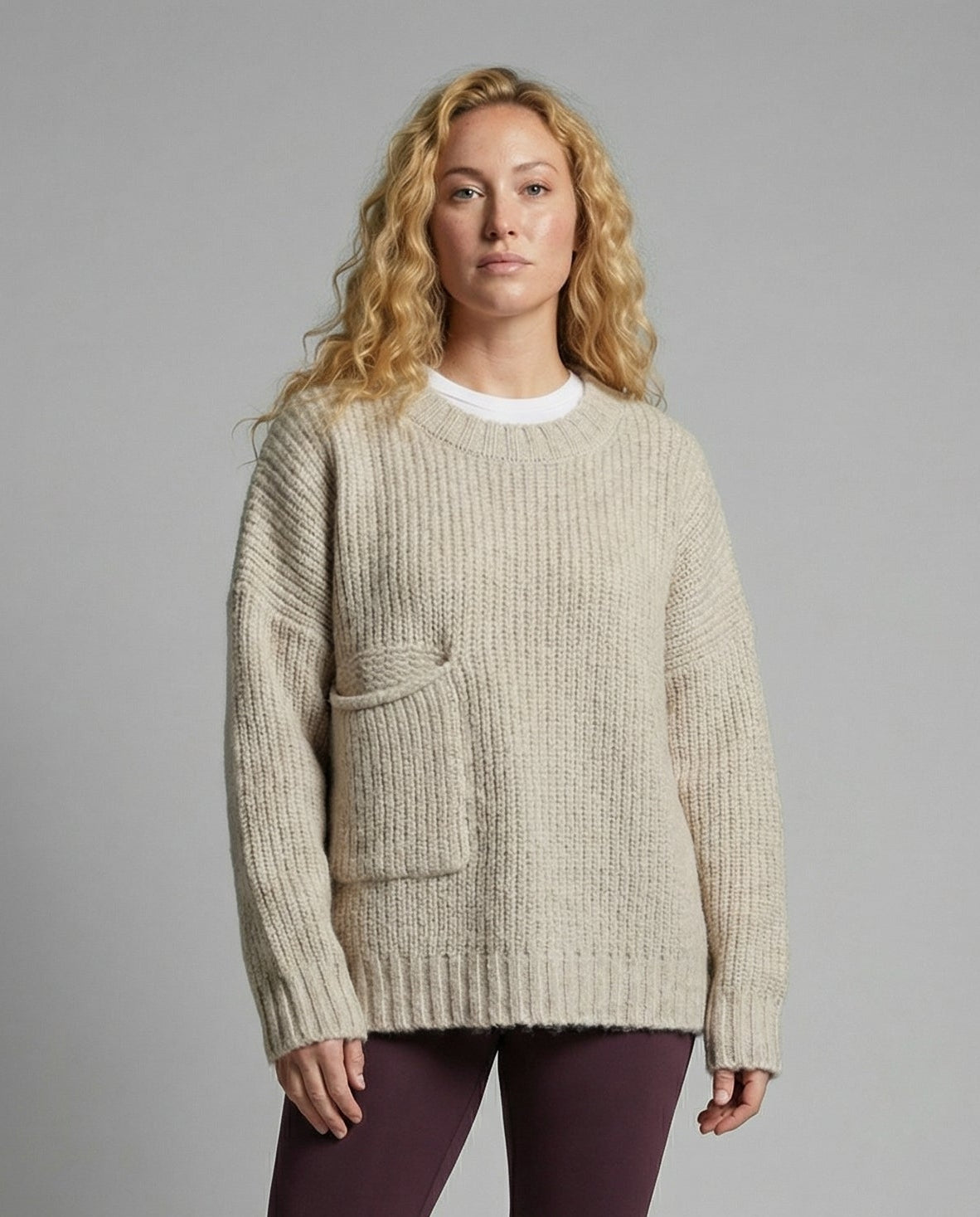 Woman wearing an oversized knit sweater with a front pocket
