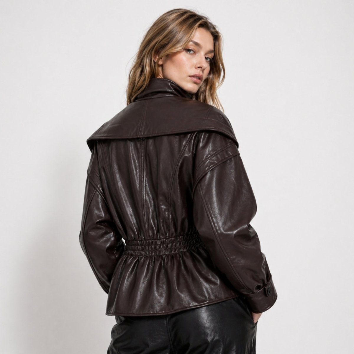Woman wearing a cinched waist faux leather funnel neck jacket
