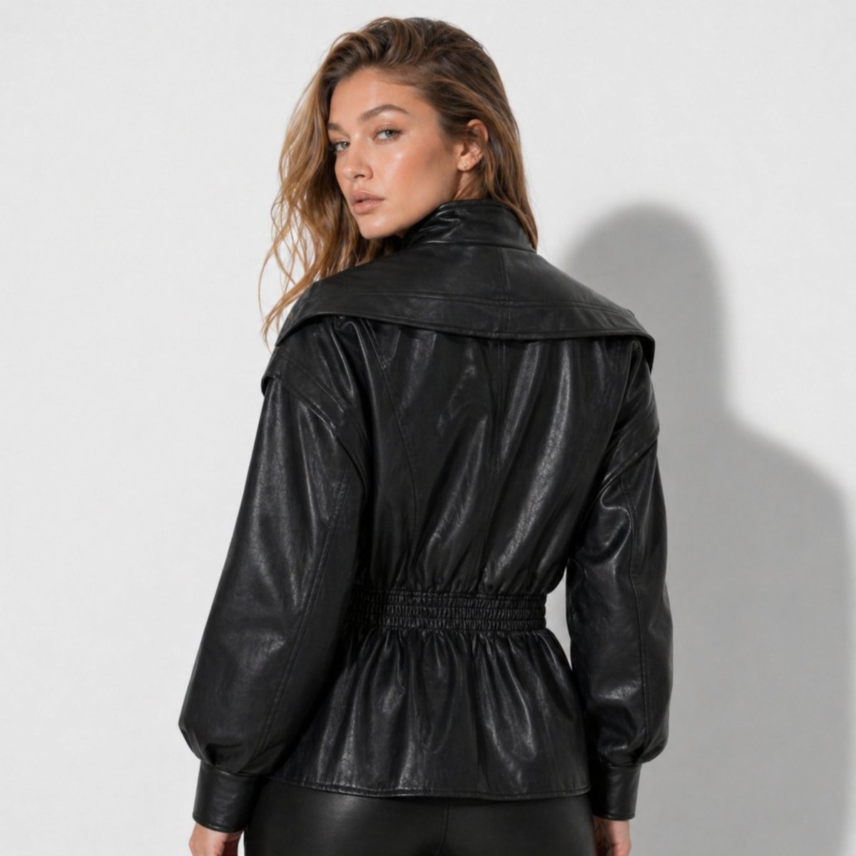 Woman wearing a cinched waist faux leather funnel neck jacket