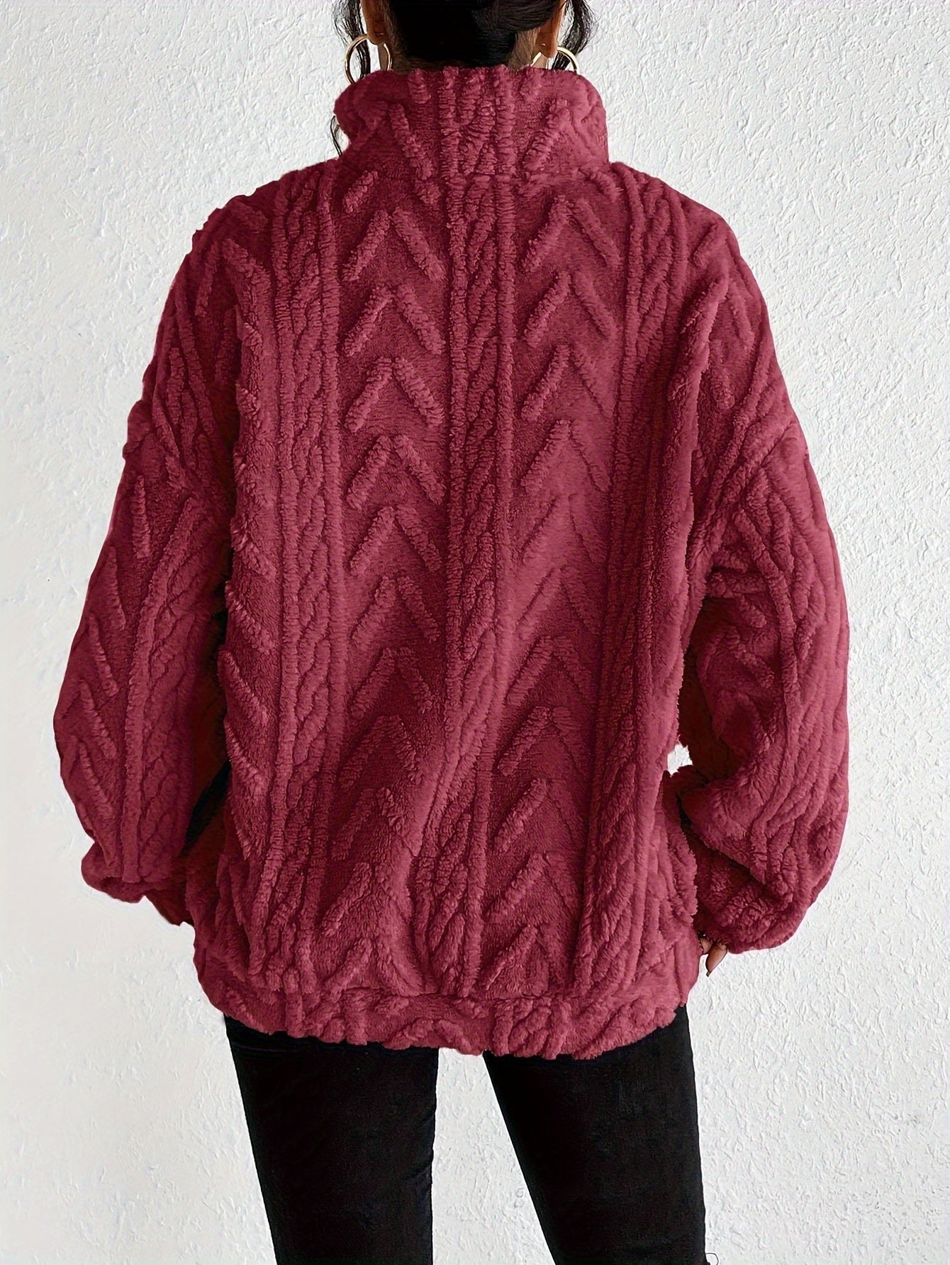 Woman wearing a cable knit fleece lined half zip sweater