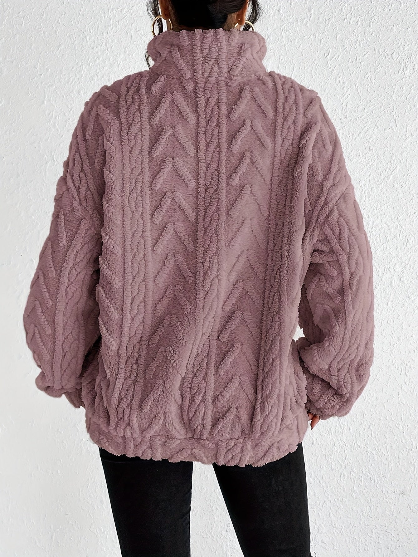 Woman wearing a cable knit fleece lined half zip sweater