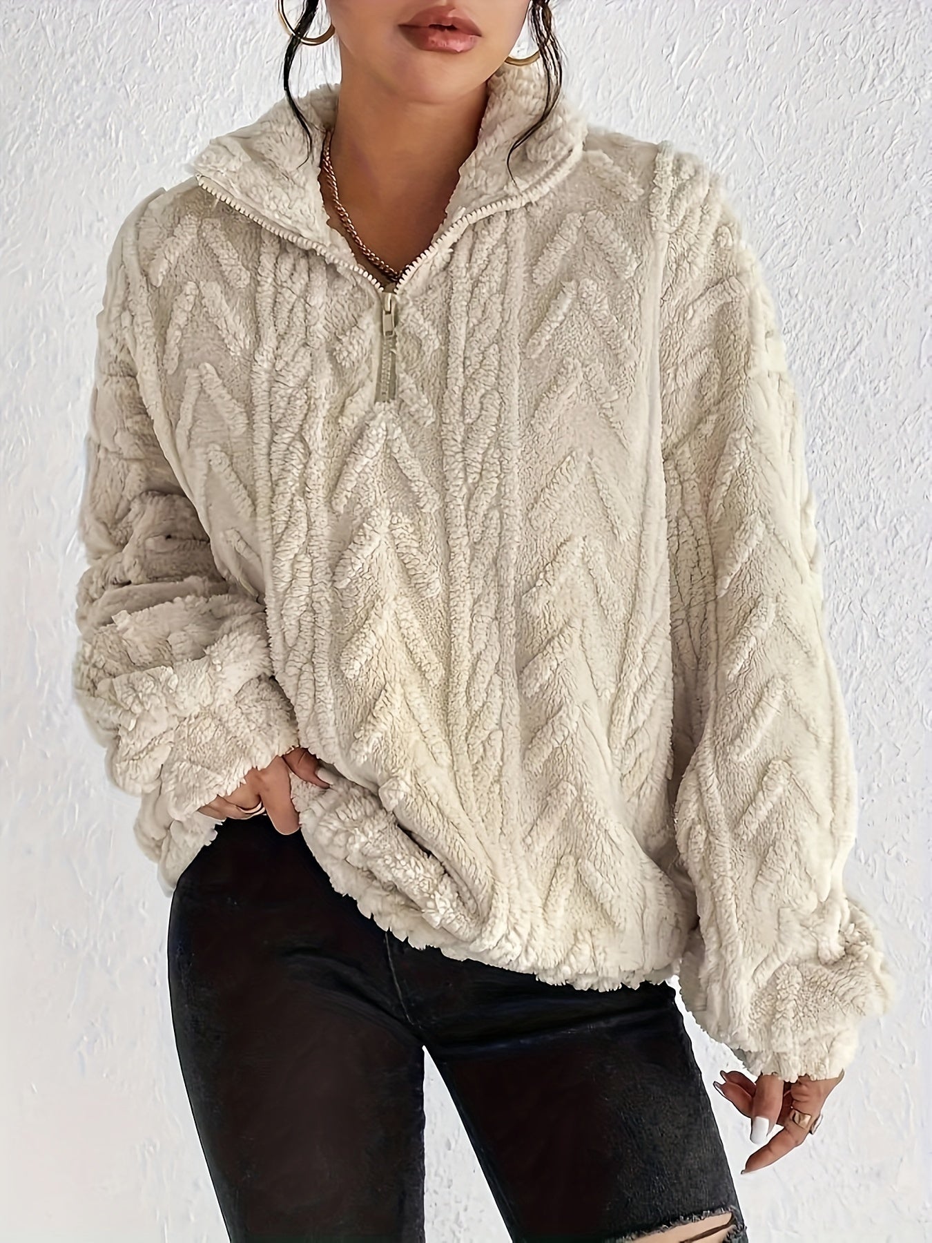 Woman wearing a cable knit fleece lined half zip sweater