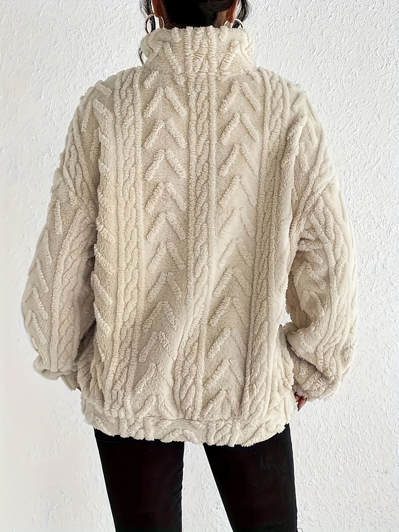 Woman wearing a cable knit fleece lined half zip sweater