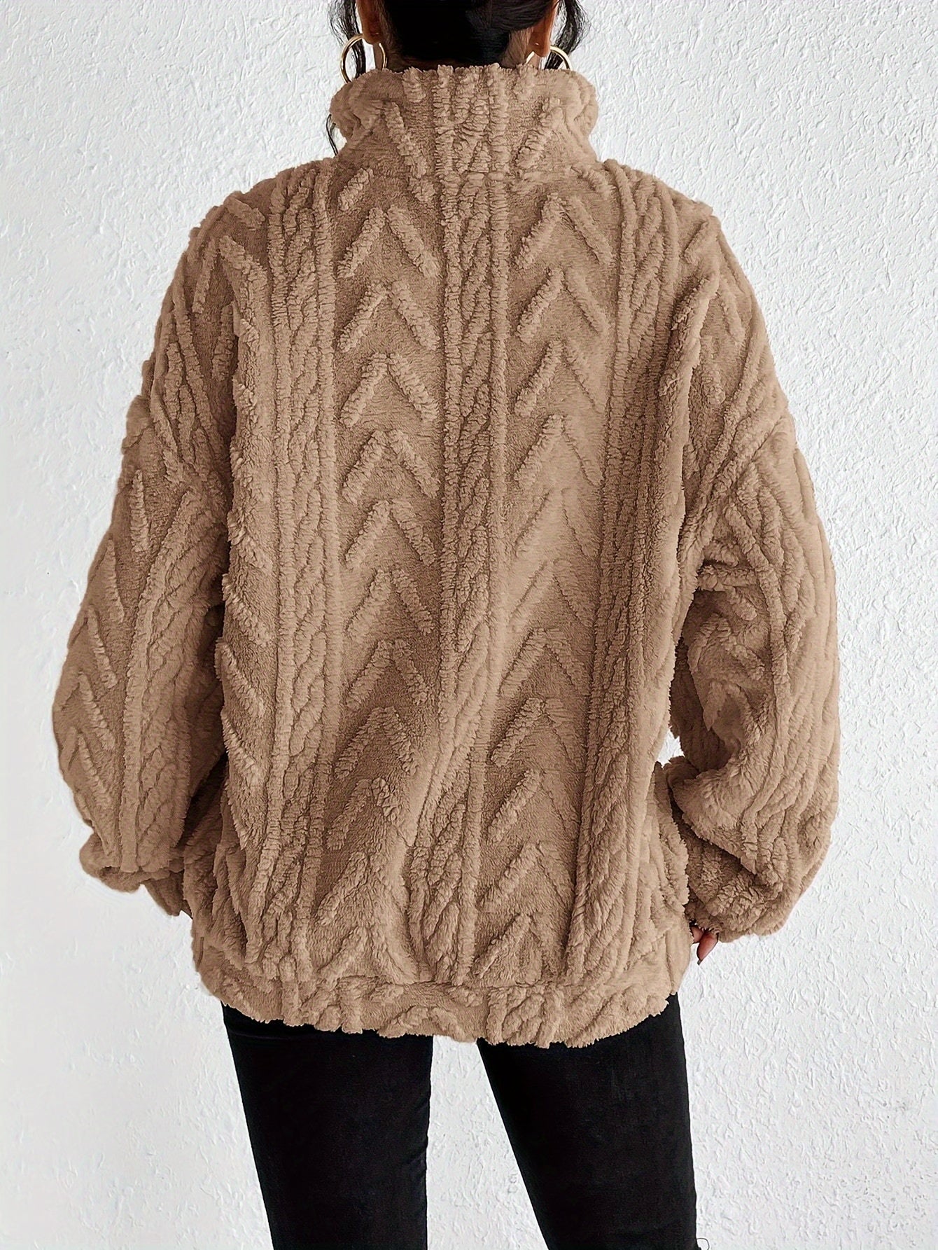 Woman wearing a cable knit fleece lined half zip sweater