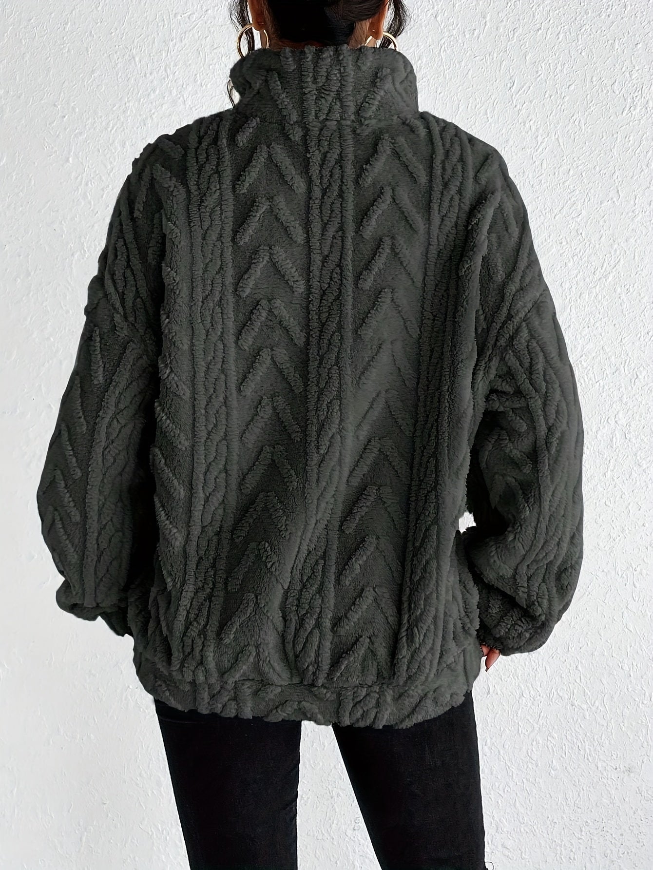 Woman wearing a cable knit fleece lined half zip sweater