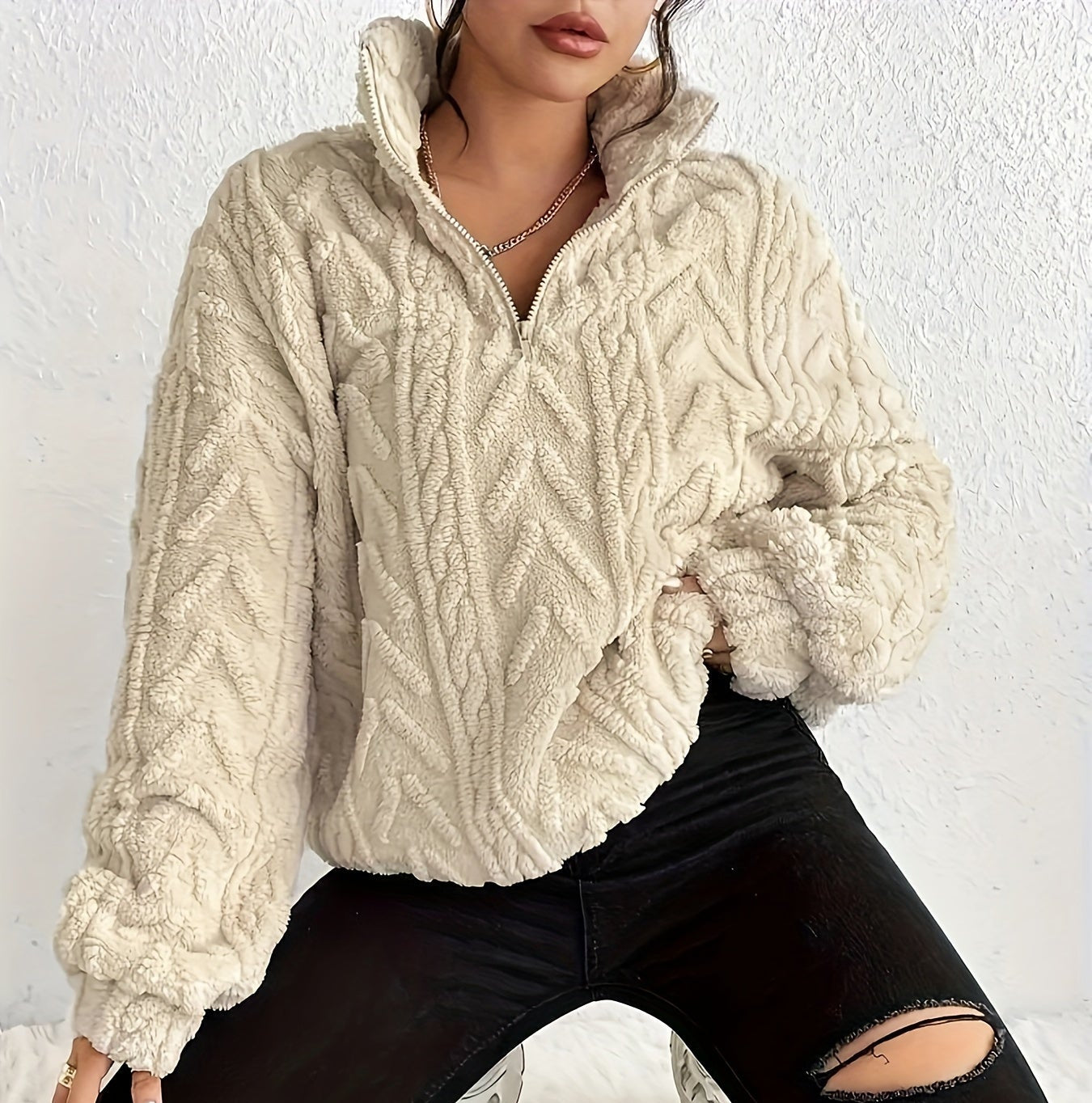 Woman wearing a cable knit fleece lined half zip sweater