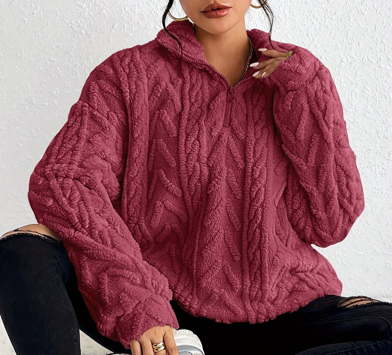 Woman wearing a cable knit fleece lined half zip sweater