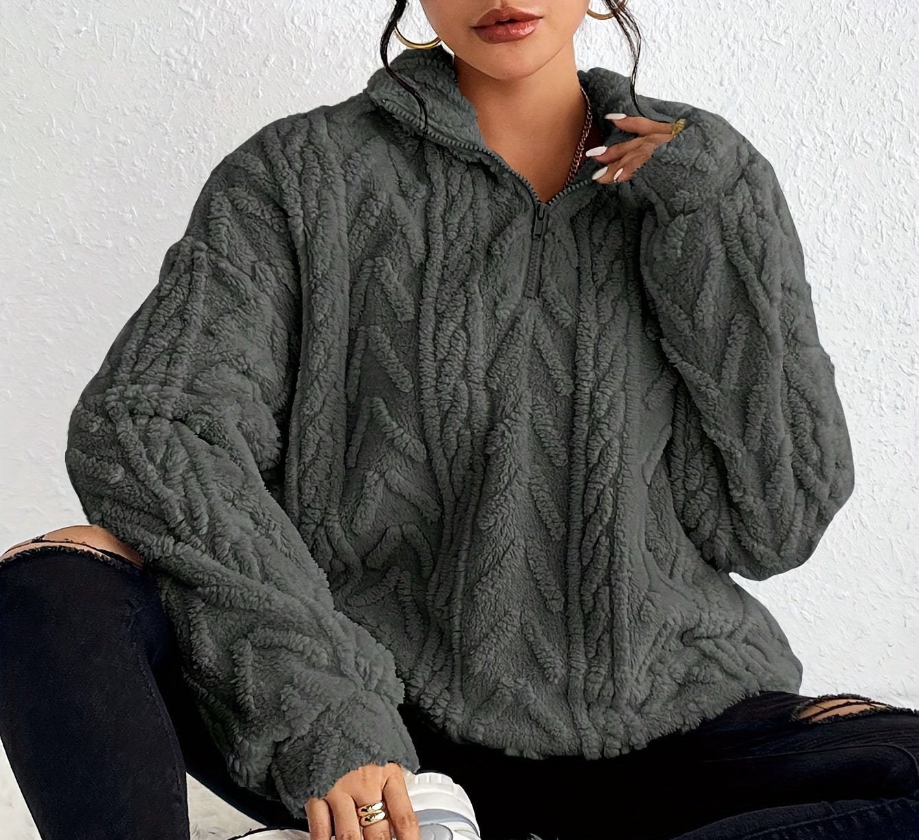 Woman wearing a cable knit fleece lined half zip sweater