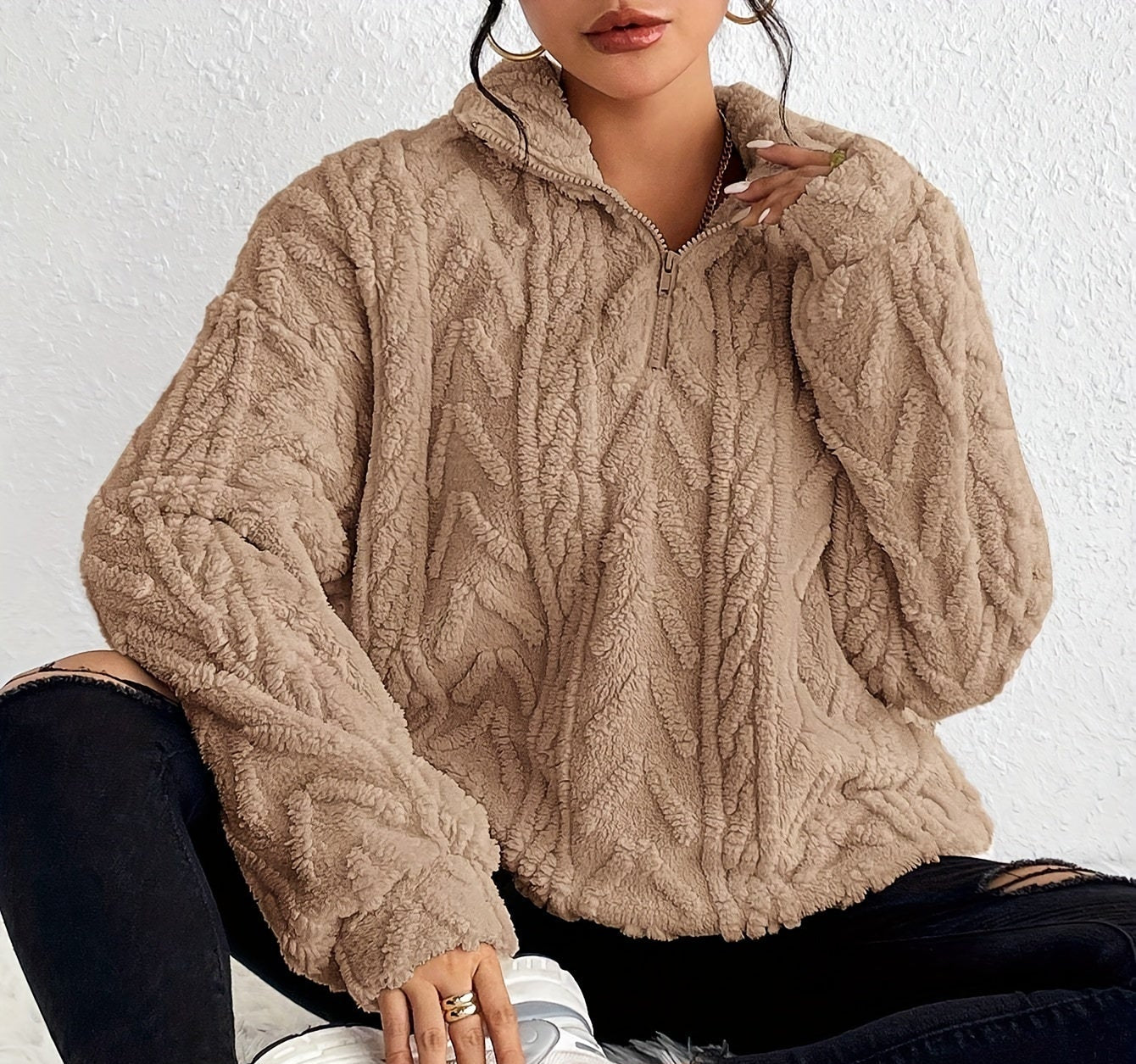 Woman wearing a cable knit fleece lined half zip sweater
