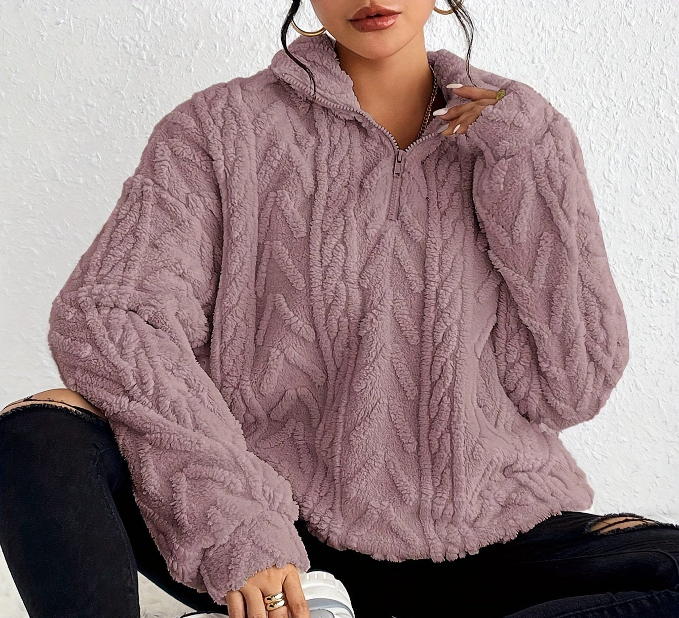 Woman wearing a cable knit fleece lined half zip sweater