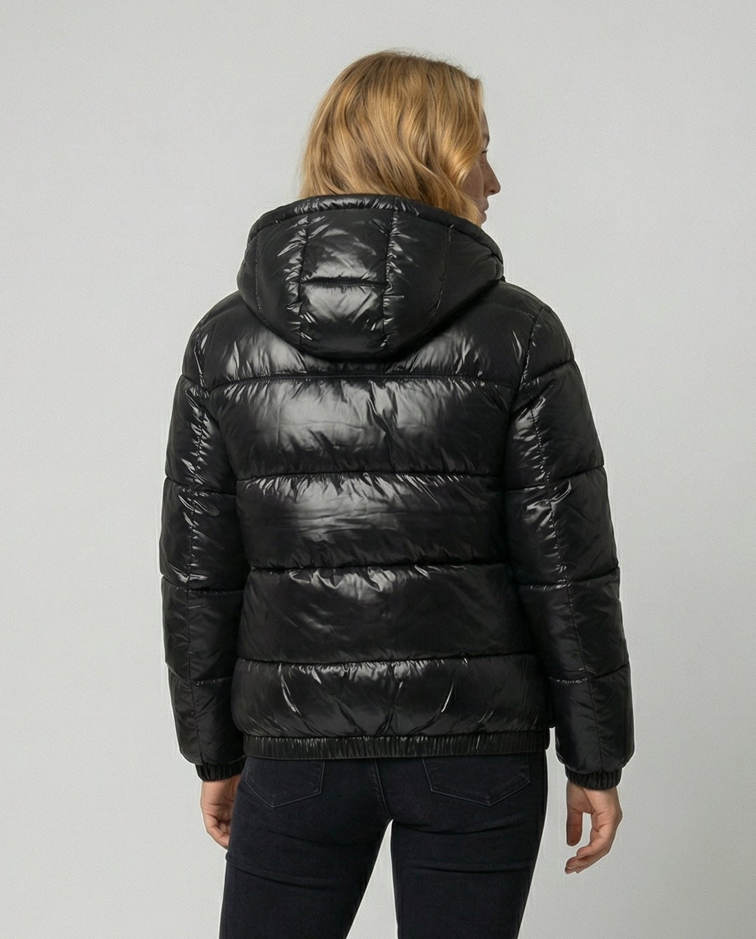 Person wearing a hooded quilted unisex puffer jacket