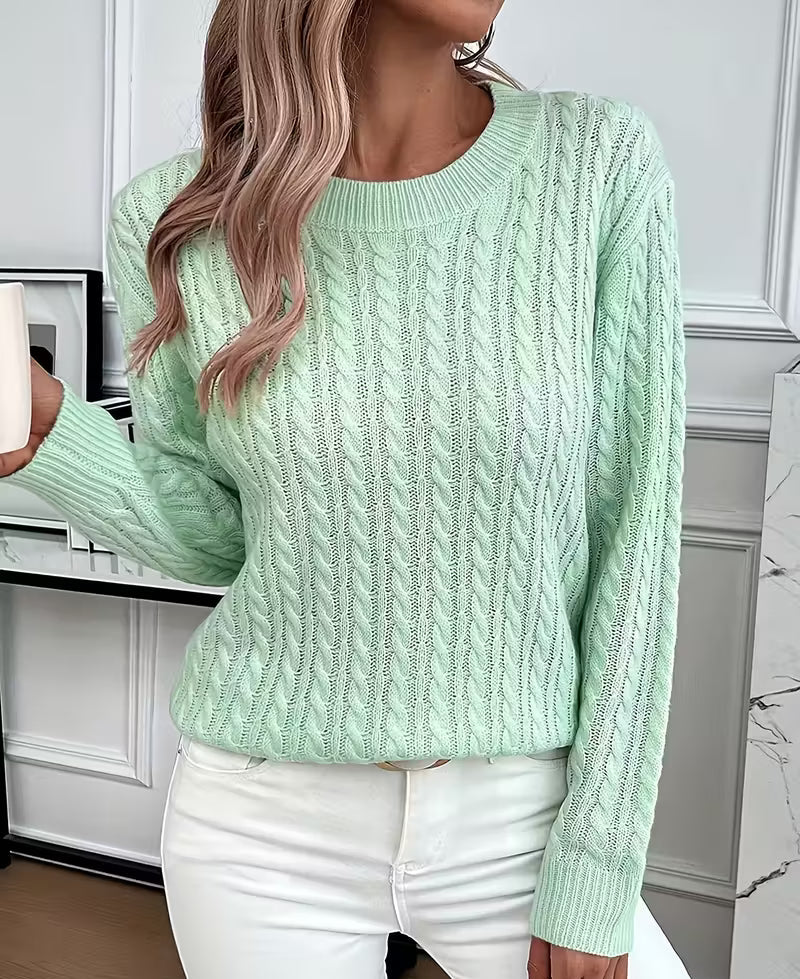 Woman wearing a cable knit crewneck pullover sweater