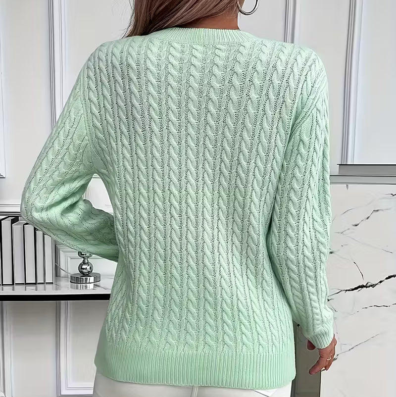 Woman wearing a cable knit crewneck pullover sweater