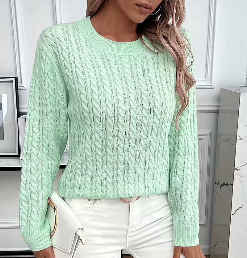 Woman wearing a cable knit crewneck pullover sweater