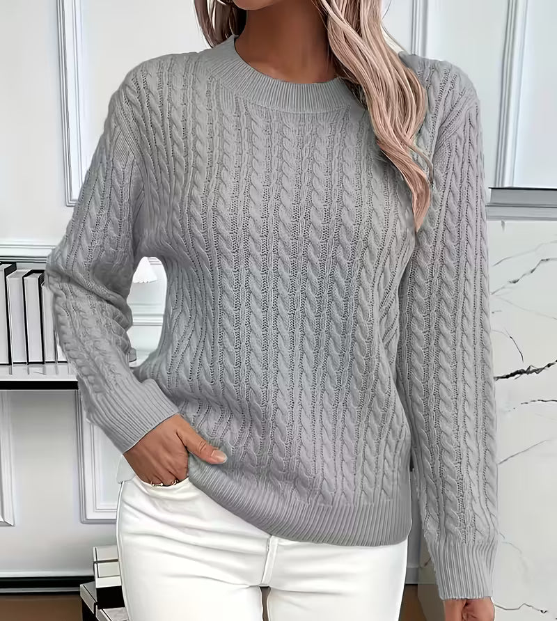Woman wearing a cable knit crewneck pullover sweater